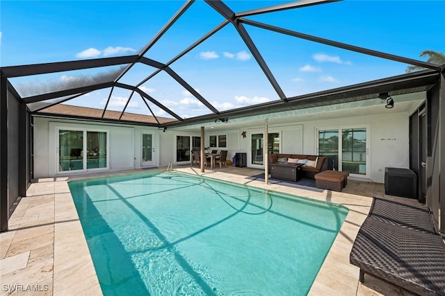 pool with an outdoor living space, glass enclosure, and a patio