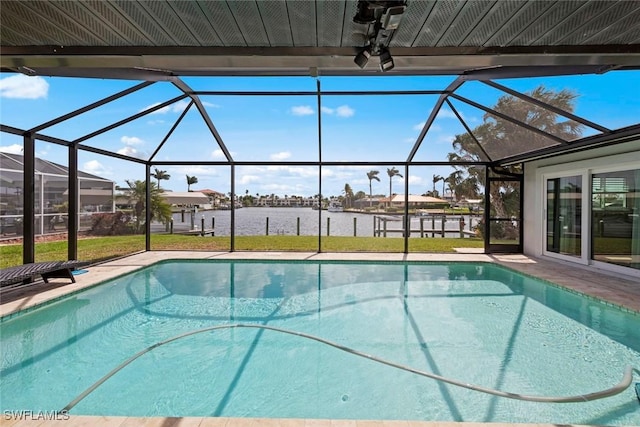 pool with glass enclosure, a water view, a yard, and a patio