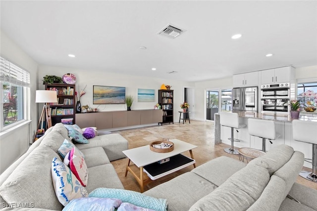 living area featuring visible vents and recessed lighting