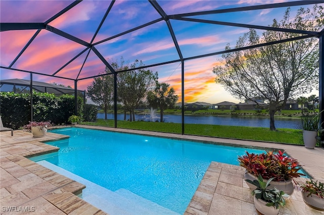 pool at dusk with a patio, an outdoor pool, a water view, and a lanai