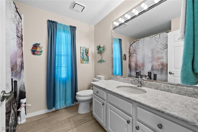 full bath with vanity, toilet, wood finished floors, and baseboards