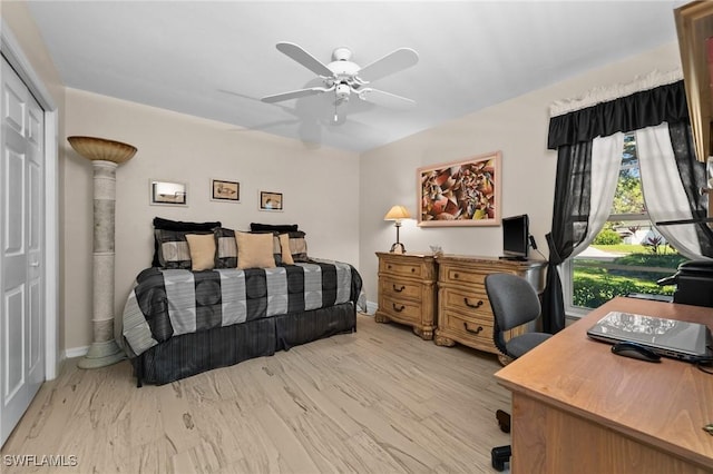 bedroom featuring light wood finished floors, baseboards, a closet, and a ceiling fan