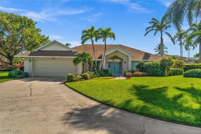 single story home featuring stucco siding, driveway, an attached garage, and a front yard