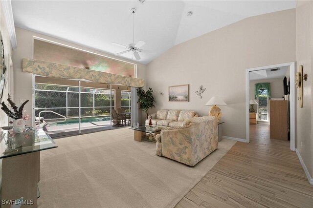 living room with plenty of natural light, high vaulted ceiling, and a ceiling fan