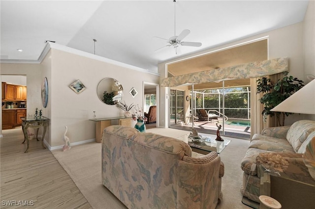 living room with crown molding, a ceiling fan, baseboards, and light wood finished floors