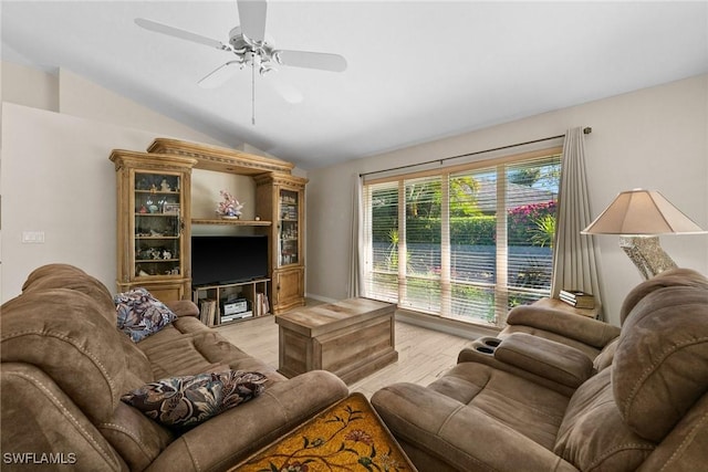 living room featuring light wood finished floors, a ceiling fan, and lofted ceiling