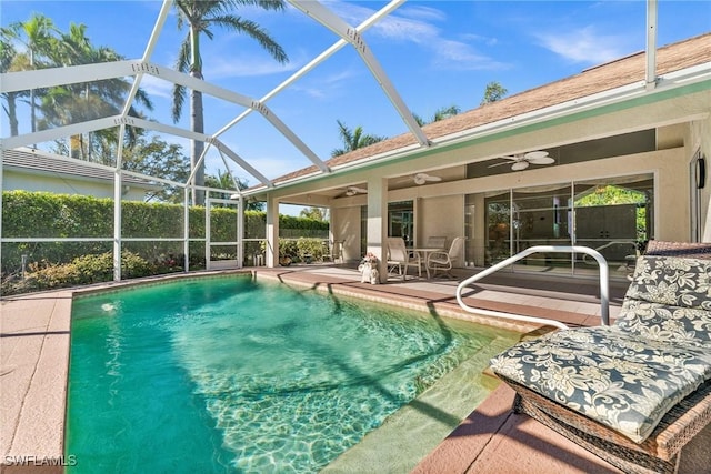 view of swimming pool with a fenced in pool, a patio, glass enclosure, and a ceiling fan