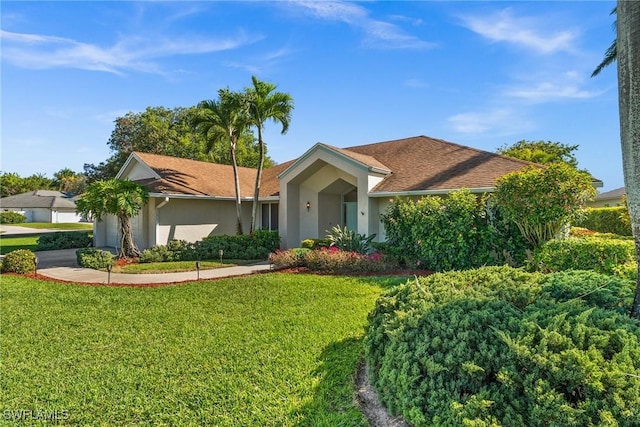 ranch-style house featuring stucco siding, an attached garage, driveway, and a front lawn