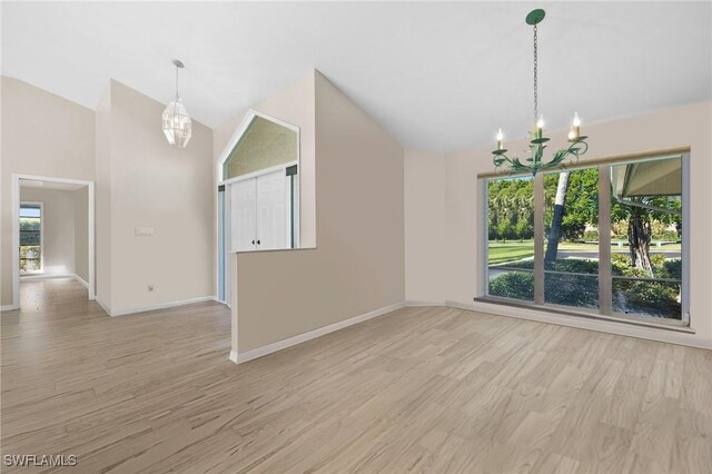 10164 Boca Ct, Naples, FL 34109 - unfurnished dining area with a chandelier, lofted ceiling, plenty of natural light, and light wood-style flooring