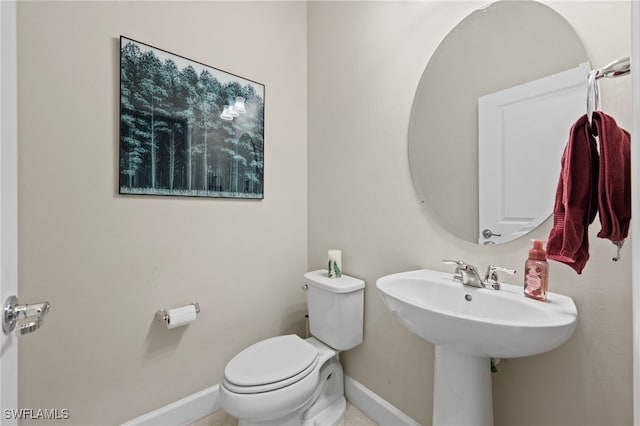 bathroom featuring baseboards and toilet