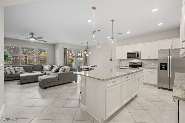 kitchen with tasteful backsplash, visible vents, light tile patterned floors, white cabinets, and stainless steel appliances