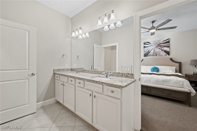 ensuite bathroom featuring a sink, ensuite bath, double vanity, and tile patterned flooring