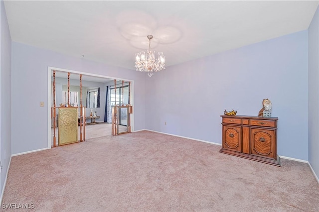 empty room with baseboards, carpet, and an inviting chandelier