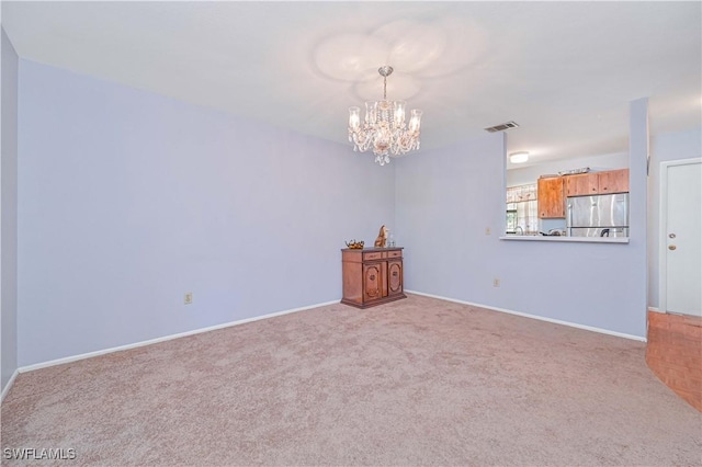 unfurnished room with baseboards, visible vents, carpet floors, and a chandelier