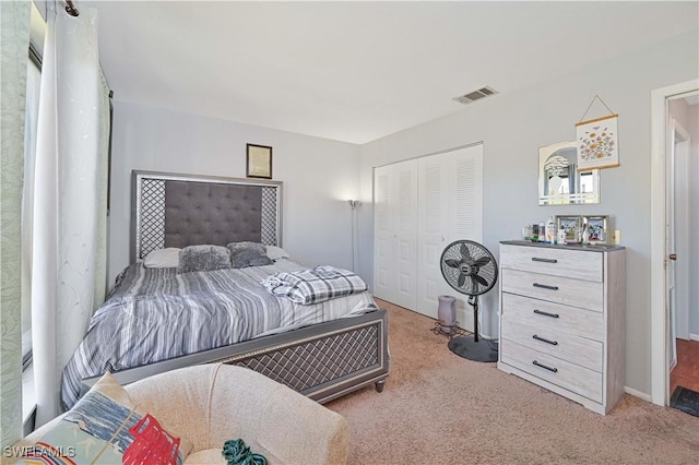 carpeted bedroom featuring baseboards, visible vents, and a closet