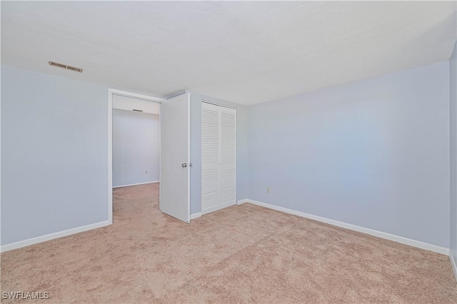 empty room with carpet, baseboards, and visible vents