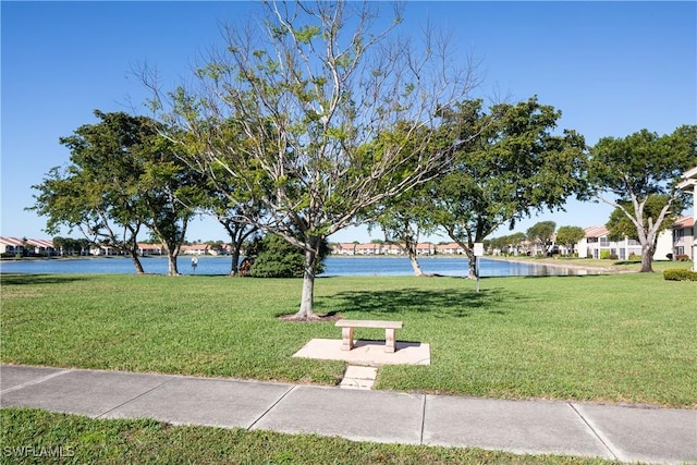 view of home's community featuring a lawn and a water view