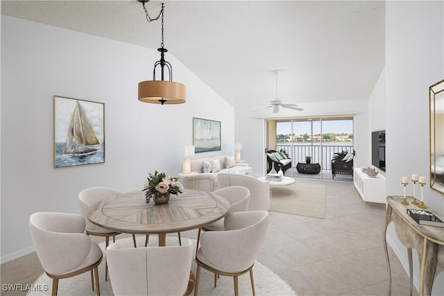 dining space with light tile patterned floors, baseboards, high vaulted ceiling, and ceiling fan