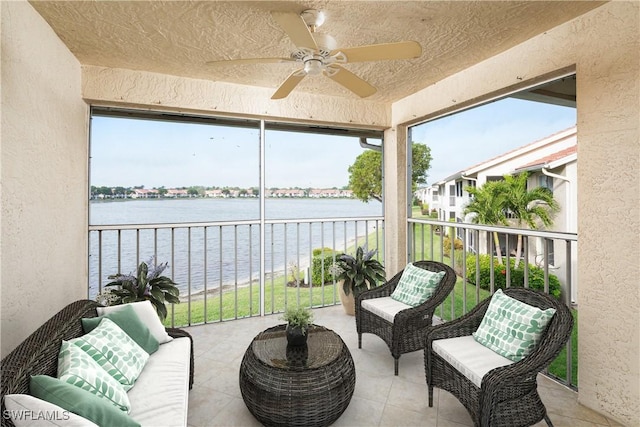 sunroom / solarium featuring a water view and ceiling fan