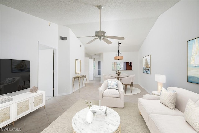 living area with a textured ceiling, tile patterned floors, visible vents, and ceiling fan