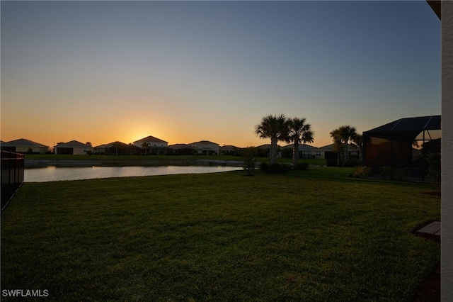 yard at dusk with a water view and a residential view