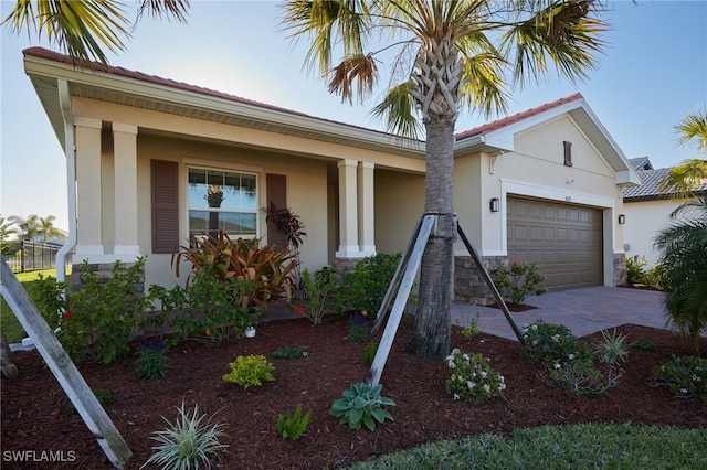 single story home featuring stucco siding, decorative driveway, an attached garage, and a tiled roof