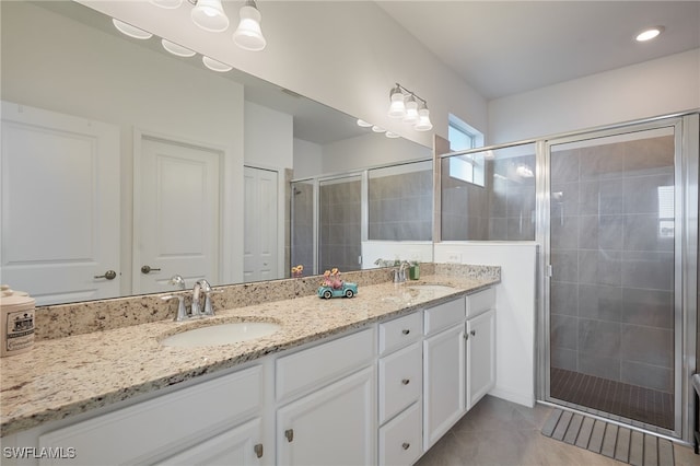 full bath with double vanity, a stall shower, tile patterned floors, and a sink