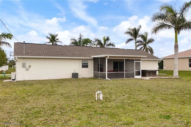 rear view of property with stucco siding, a lawn, roof with shingles, and a sunroom