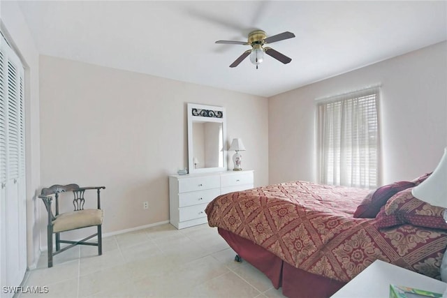 bedroom with light tile patterned floors, a closet, baseboards, and ceiling fan