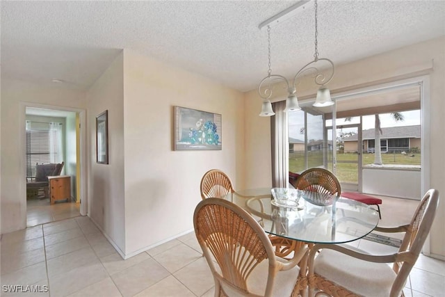 dining space featuring light tile patterned floors and a textured ceiling