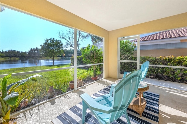 sunroom / solarium featuring a water view