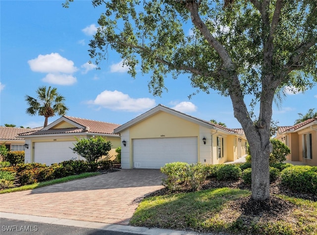 single story home with stucco siding, driveway, and an attached garage