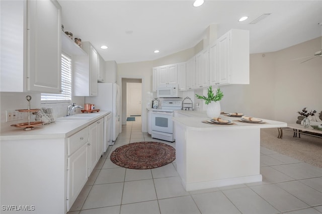 kitchen featuring white appliances, light countertops, a sink, white cabinetry, and a peninsula
