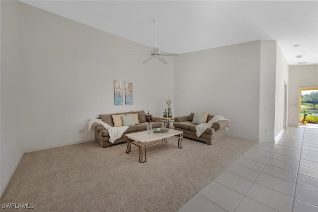 living area with tile patterned flooring, a ceiling fan, carpet, and a high ceiling