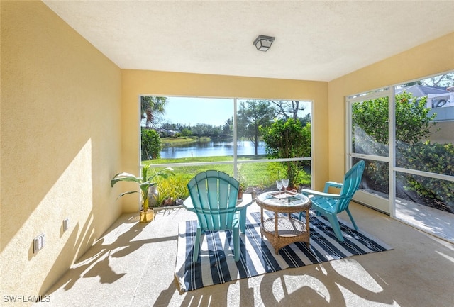 sunroom / solarium featuring a water view and concrete flooring