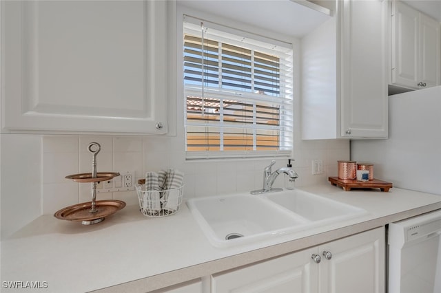 kitchen featuring a sink, dishwasher, white cabinets, and tasteful backsplash
