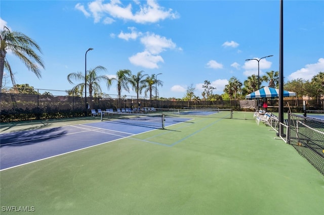 view of tennis court with fence and community basketball court