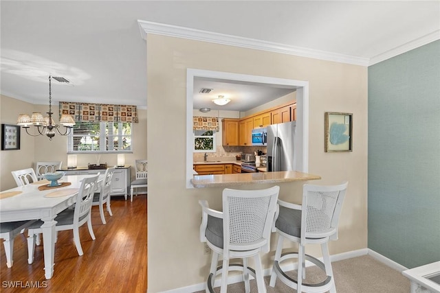 kitchen with a notable chandelier, appliances with stainless steel finishes, crown molding, and visible vents