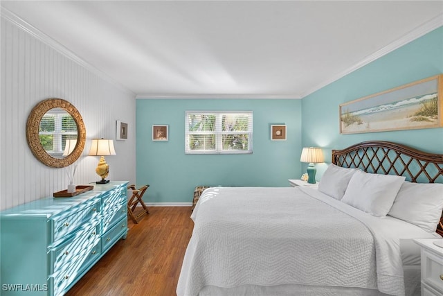 bedroom featuring baseboards, wood finished floors, and ornamental molding