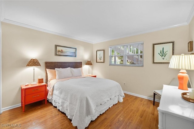 bedroom with crown molding, baseboards, and light wood finished floors