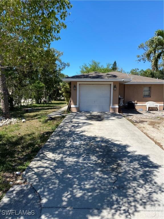 view of front of home featuring an attached garage, driveway, and stucco siding