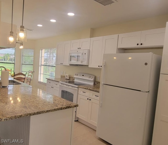 kitchen with white cabinetry, white appliances, light stone countertops, and a sink