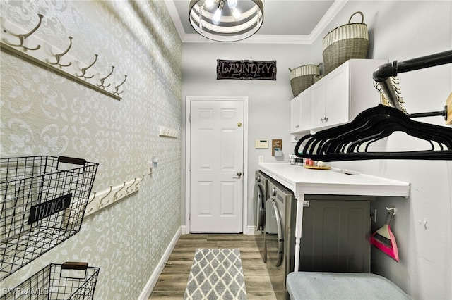 washroom with wallpapered walls, crown molding, baseboards, light wood-type flooring, and cabinet space