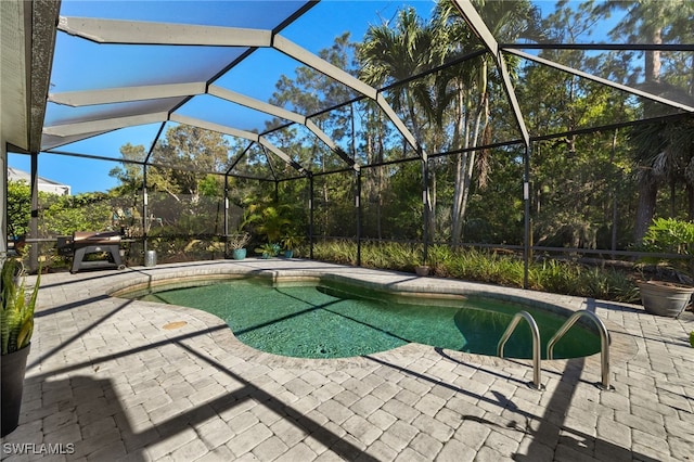 outdoor pool with a lanai and a patio area