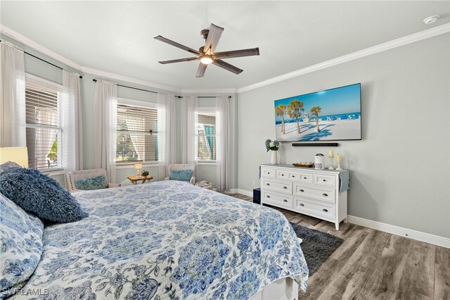 bedroom with multiple windows, wood finished floors, baseboards, and ornamental molding