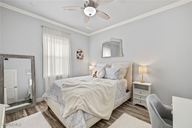 bedroom with crown molding, wood finished floors, and ceiling fan