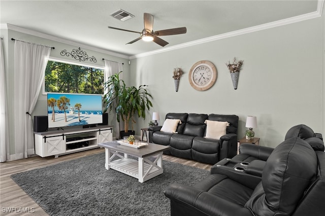 living area featuring wood finished floors, crown molding, a ceiling fan, and visible vents