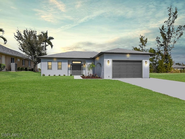 view of front of property with a front yard, stucco siding, cooling unit, a garage, and driveway