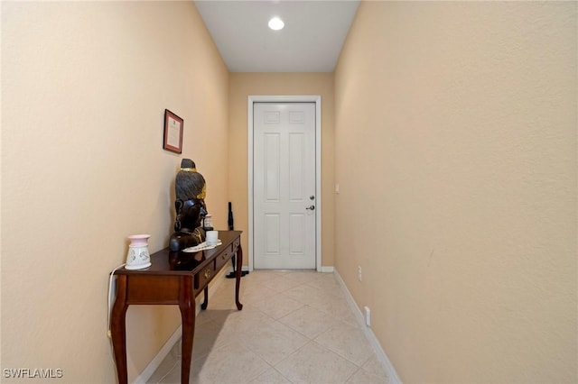 doorway to outside with light tile patterned flooring and baseboards