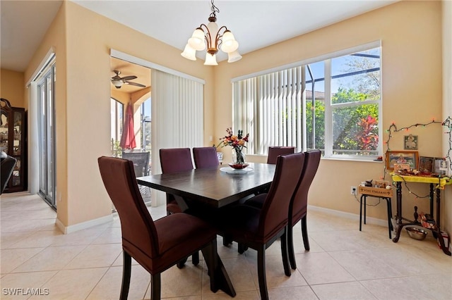 dining space featuring light tile patterned flooring, baseboards, and a chandelier